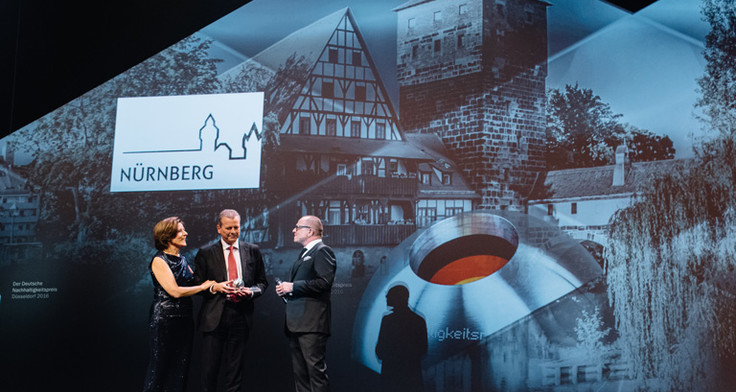 Nürnbergs Oberbürgermeister Dr. Ulrich Maly nimmt die Auszeichnung von Malu Dreyer und Stefan Schulze-Hausmann entgegen.