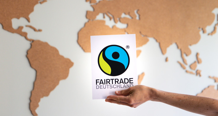 Fairtrade Deutschland Logo vor einer Weltkarte