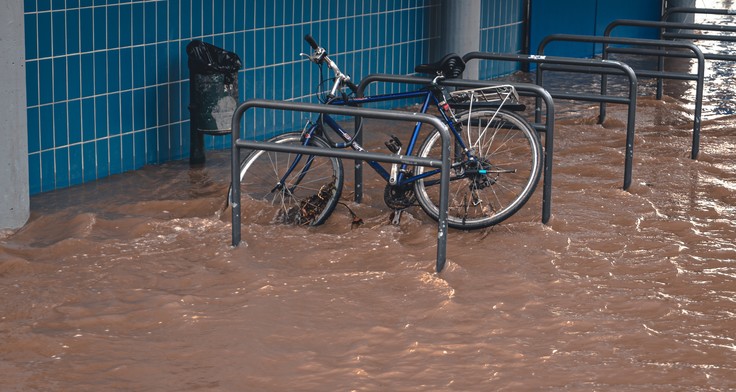 Wasser flutet einen Fahrradständer. 